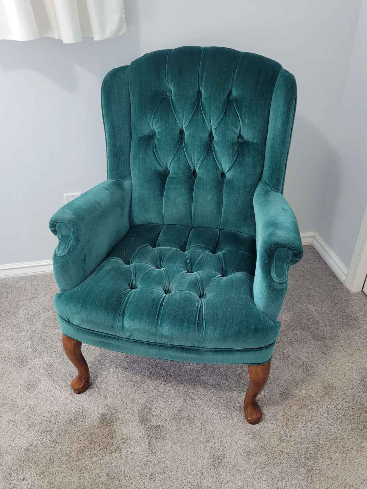 Clean teal upholstered chair on carpet after Armstrong Carpet Care service
